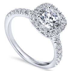 a cushion cut diamond engagement ring with halos and pave set shoulders