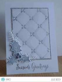 a white card with silver foil on it and a christmas tree in the center that says season's greetings