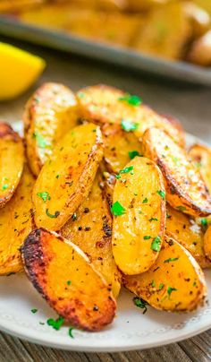 a white plate topped with fried potatoes on top of a wooden table