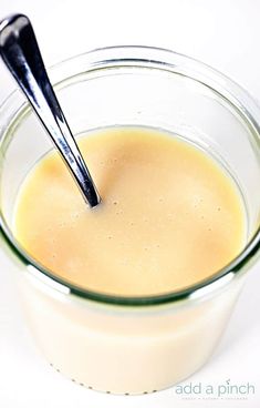 a glass bowl filled with liquid and two black spoons sticking out of the top