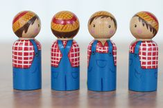 five wooden toy figures with hats and overalls