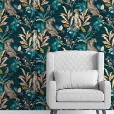 a chair sitting in front of a wallpaper with birds and flowers on green background