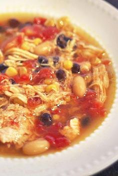 a white bowl filled with chicken and bean soup