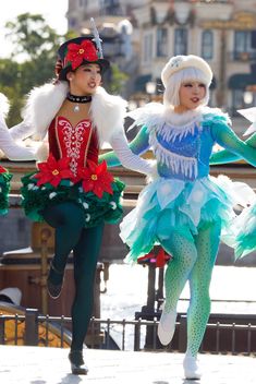 two women in costumes are running down the street