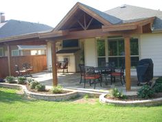 an outdoor patio with chairs and grill in the back yard