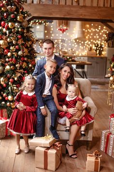 a family posing for a christmas photo in front of a tree