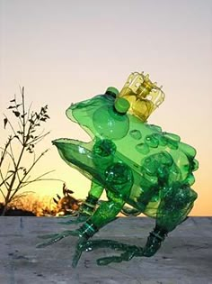 a glass frog sitting on top of a cement ground