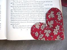 an open book with two red hearts on it and the pages are folded in half