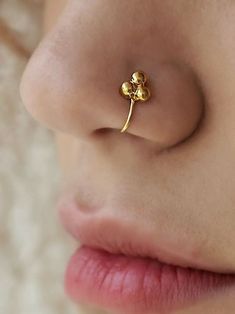 a close up view of a nose with a gold nose ring on top of it