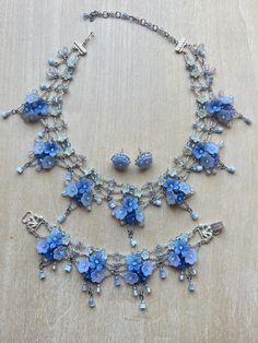 Vintage Colleen Toland Cornflower Blue Jewelry Set Necklace, Earrings and Bracelet.  This set is made in a beautiful but rare color which is periwinkle, a blue purple tone.  The flowers are resin and are hand colored.  The bead work is pale blue to crystal. The flowers are beaded together using tiny glass seed beads.  The findings are a plated silver. The flowers are a single flower stud earring with hypo-allergenic studs. The necklace has a lobster claw closure with a 4 inch extender so as the Blue Jewelry Set, Purple Tone, Flower Stud, Set Necklace, Single Flower, Blue Jewelry, Flower Earrings Studs, Flower Studs, Cornflower Blue