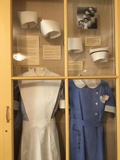 a display case filled with dresses and hats