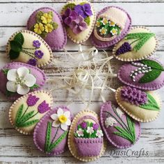 a wreath made out of purple and white decorated cookies with flowers in them on a wooden surface