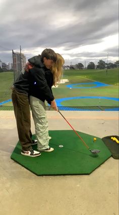 a man and woman playing golf on a green course