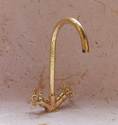 a gold faucet shaped like a tree branch