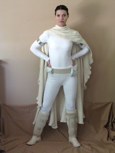 a woman dressed in star wars garb and boots standing next to a brown wall