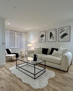 a living room with white furniture and black accents