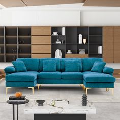 a living room with blue couches and bookshelves on the wall behind it