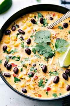 a black bean and corn soup in a skillet with a lime wedge on the side