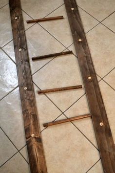 three pieces of wood sitting on top of a tiled floor