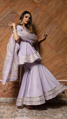 PRODUCT DESCRIPTION: TOP : Cotton silk SHARARA: Cotton silk Dupatta: Organza LINING: COTTON Color: LILAC work : Gotta lace work, allover Kurta ,Shararas and Dupatta. No. Of Components : Set of 3 Wash Care : Dry Clean Customization : Only Size and Length Of Product SKU#: 11403163PR Disclaimer: All our pieces are handcrafted in our manufacturing unit .We Ensure that our pieces are shot professionally under controlled lighting. Colours tend to be perceived differently depending on factors such as s Fitted Cotton Silk Sharara With Sheer Dupatta, Fitted Sharara With Sheer Dupatta In Cotton Silk, Fitted Sharara With Sheer Dupatta, Fitted Cotton Silk Sharara, Designer Silk Dupatta With Lace Work, Purple Silk Sets With Chikankari Embroidery, Fitted Purple Sharara With Chikankari Embroidery, Unstitched Chanderi Sharara With Lace Work, Elegant Purple Sharara With Chikankari Embroidery