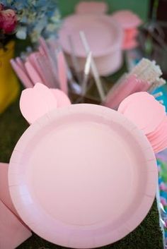 pink plates and utensils are arranged on the table