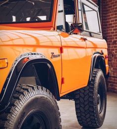 an orange truck parked next to a brick building