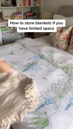 a bed with a white comforter and pillows on it that says, how to store blankets if you have limited space