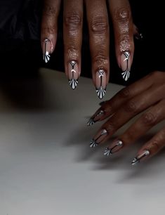 two hands with black and white nail polish on them