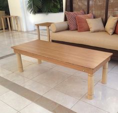 a couch and coffee table in a room with tile flooring on the floor,