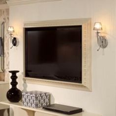 a flat screen tv mounted to the side of a wall next to a vase and lamp