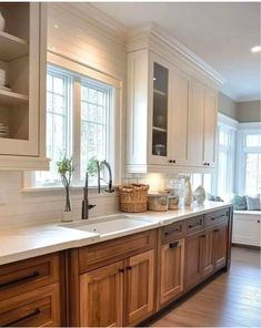 a large kitchen with wooden cabinets and white counter tops, along with hardwood flooring