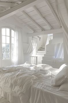 an unmade bed with white sheets and pillows in a bedroom next to a window