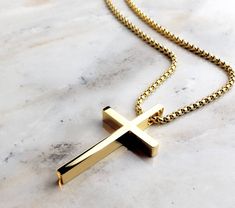 "《《 SPIRITUAL COLLECTION 》》 THE DETAILS The \"SLEEK GOLD CROSS\" is designed with an ultra shiny Mirror Finish Gold Stainless Steel Cross Pendant, hung from a Gold Stainless Steel Box Chain available in your choice of length! 💠🔷️💠View entire SPIRITUAL COLLECTION here: https://www.etsy.com/shop/mrmackjewelry/?section_id=27046119 MATERIALS * 1 1/2\" × 3/4\" Gold Stainless Steel Cross Pendant * 3mm Gold Stainless Steel Box Chain * Gold Stainless Steel Lobster Clasp ⤵️NOTE: Our GOLD Stainless Ste Gold Adjustable Chain Jewelry For Father's Day, Father's Day Gold Jewelry With Adjustable Chain, Gold Cross Necklace As Gift, Classic Gold Necklaces For Father's Day, Gold Jewelry With Polished Finish For Father's Day, Gold Stainless Steel Cross Necklace As Gift, Gold Stainless Steel Cross Necklace For Gift, Gold Stainless Steel Minimalist Cross Necklace, Gold Minimalist Stainless Steel Cross Necklace