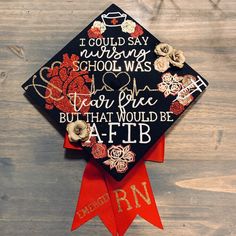 a graduation cap that has been decorated with flowers and writing on it, sitting on top of a wooden table