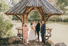 the bride and groom are getting married at the gazebo by the water's edge