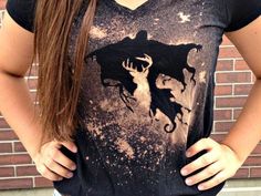 a woman standing in front of a brick wall wearing a t - shirt with an image of a deer on it