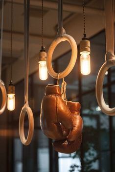 several light bulbs hang from the ceiling with boxing gloves hanging from them