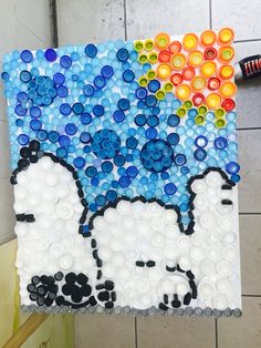 a painting made out of plastic bottle caps with an image of a sheep on it