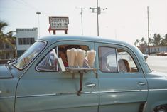 an old car with milkshakes in the passenger seat