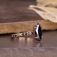 a black and white diamond ring sitting on top of a table