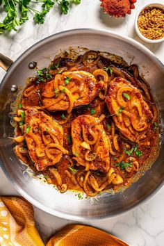 a pan filled with pasta and onions on top of a table next to other ingredients