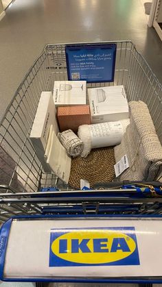 a shopping cart filled with items on top of a floor next to a sign that says ikea