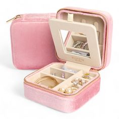 an open pink velvet jewelry box with rings and bracelets