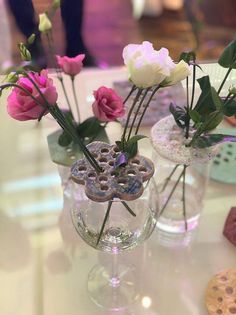 three vases with flowers in them on a table