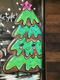 a painted christmas tree on the side of a store front window with words be safe