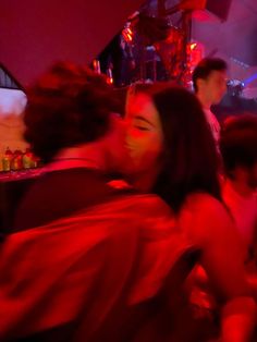 two women sitting next to each other in a room with red lights on the walls