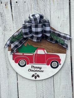 a christmas ornament with a red truck and pine tree on the front door