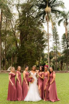 a group of women standing next to each other on top of a lush green field