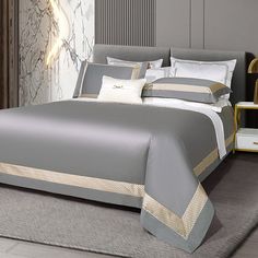 a bed with grey and gold sheets in a room