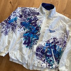 "This piece is a vintage Reebok windbreaker from the 1990s. This piece from the sportswear brand has a very retro look with an all over print abstract design. It has a full zip front, two side hand warmer pockets and little embroideries of the Reebok logo on the front breast as well as on the back under the collar. -100% Nylon Shell -One yellow splotch on the back (pictured) Tag Size: Medium *refer to measurements for true fit* Pit to Pit: 24\" Length: 25\" Please also assess the photos and measurements carefully using your own personal judgement as we do not accept returns. Keep in mind that this is a piece of vintage clothing that may hold a residual scent from its past. While we wash all of the clothing we sell (except for certain items which are steam cleaned) we cannot guarantee that Sporty Graphic Print Windbreaker, Sporty Windbreaker With Graphic Print, Sporty Windbreaker With Graphic Print For Sports, Reebok Retro, Reebok Jacket, Reebok Windbreaker, Retro Windbreaker, Windbreaker Vintage, Reebok Logo